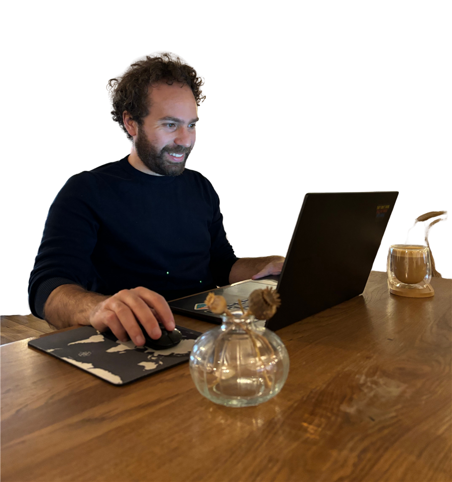 Jose, fundador de Webspire, trabajando y sonriendo frente a su portátil en un escritorio de madera